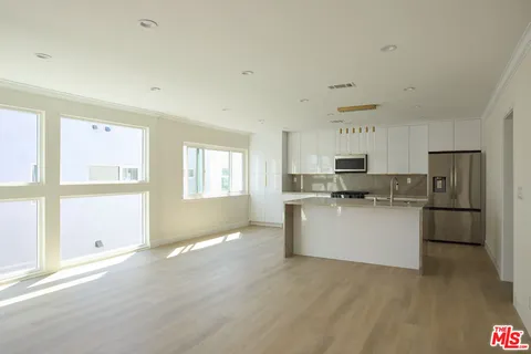 a kitchen with refrigerator and cabinets