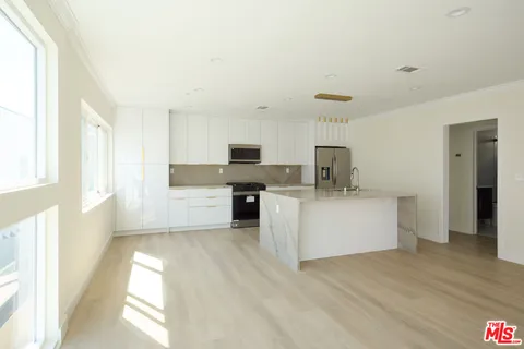 a kitchen with stainless steel appliances a refrigerator sink and cabinets