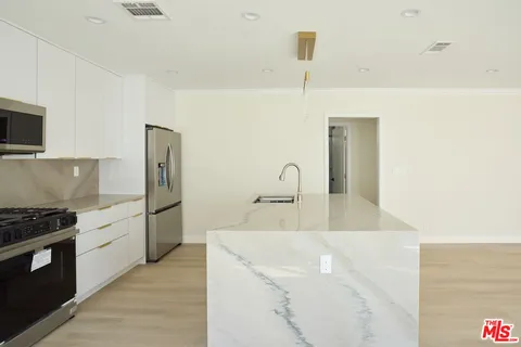 a kitchen with stainless steel appliances granite countertop a sink and a stove
