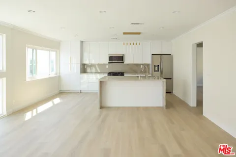 a view of a kitchen with cabinets and wooden floor