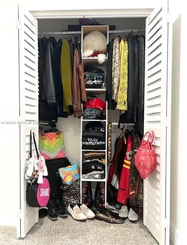 a view of walk in closet with clothes and shoes