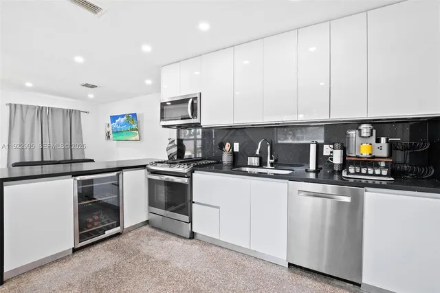 a kitchen with white cabinets and sink