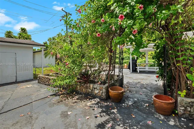 a view of a backyard with table and chairs and potted plants