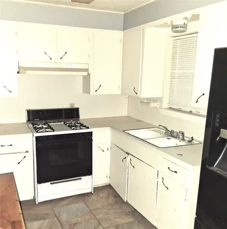 a kitchen with a stove and white cabinets