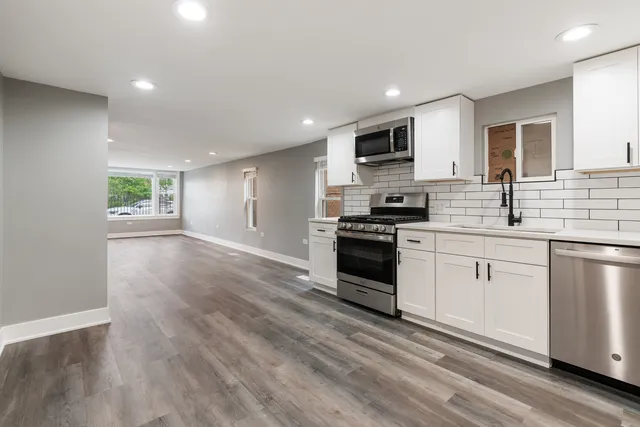 a kitchen with granite countertop a refrigerator stove top oven and sink