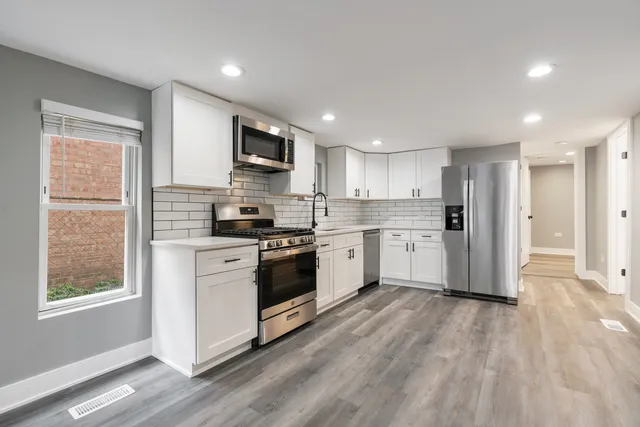 a kitchen with stainless steel appliances a refrigerator sink and microwave