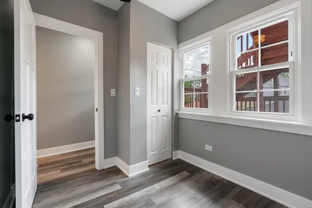 a view of empty room with window and wooden floor