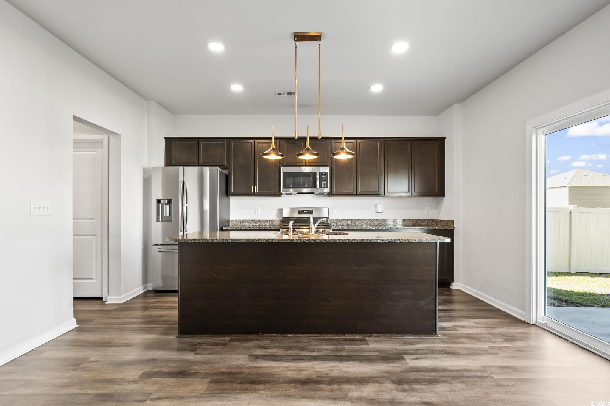 733 Lambeth Lane Conway, SC 29526 - Photo 12 of 40 Kitchen featuring dark brown cabinetry, decorative light fixtures, stainless steel appliances, a center island with sink, and recessed lighting