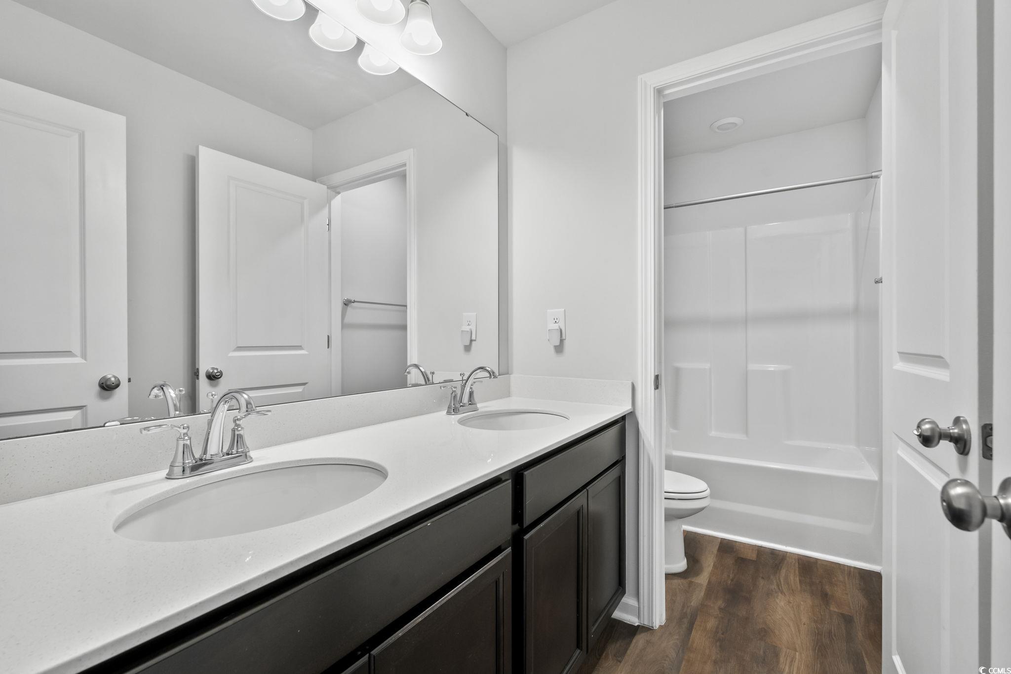 733 Lambeth Lane Conway, SC 29526 - Photo 26 of 40 Full bath featuring double vanity, dark wood finished floors, and bathtub / shower combination