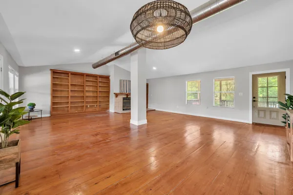 a kitchen with stainless steel appliances kitchen island wooden floors stove and white cabinets