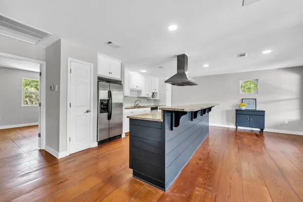 a kitchen with granite countertop a stove cabinets and wooden floor