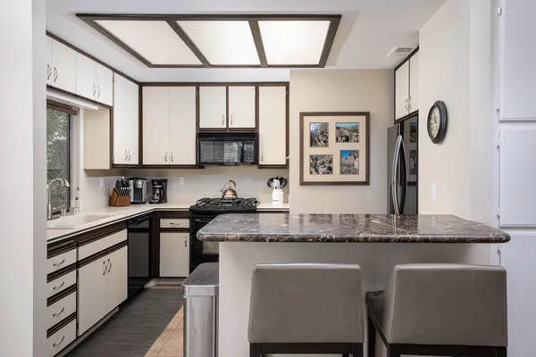 a kitchen with stainless steel appliances granite countertop a stove a sink and a microwave