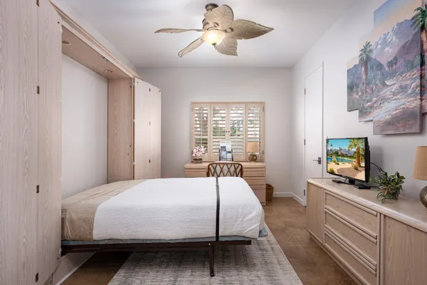 a bedroom with a bed window and a flat screen tv