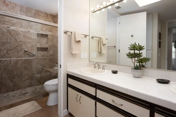 a bathroom with a sink a toilet and shower