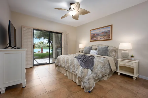a spacious bedroom with a bed and a flat screen tv