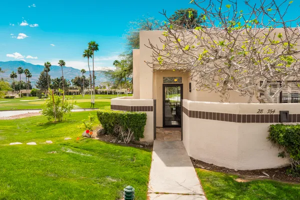 a view of a house with a yard and sitting area