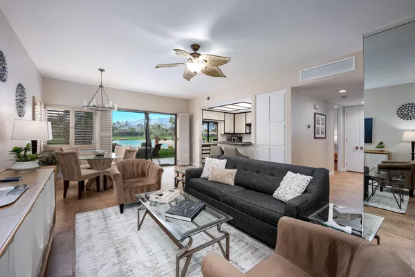 a living room with furniture kitchen view and a large window