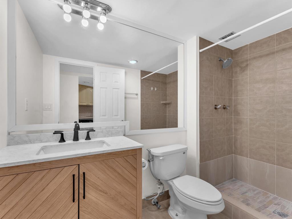 6901 Environ Boulevard, Unit 4D Lauderhill, FL 33319 - Photo 11 of 23 a bathroom with a sink a toilet a mirror a vanity and shower