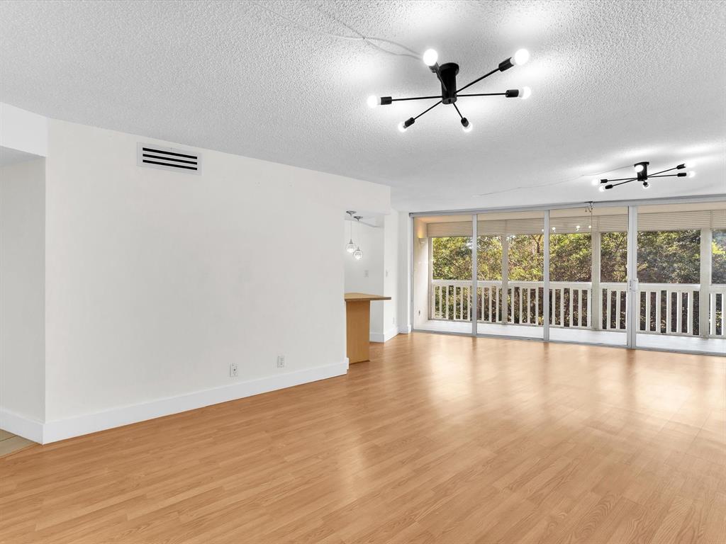 6901 Environ Boulevard, Unit 4D Lauderhill, FL 33319 - Photo 5 of 23 an empty room with wooden floor and windows