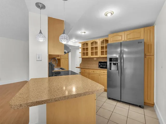 a kitchen with stainless steel appliances a refrigerator and a counter top space