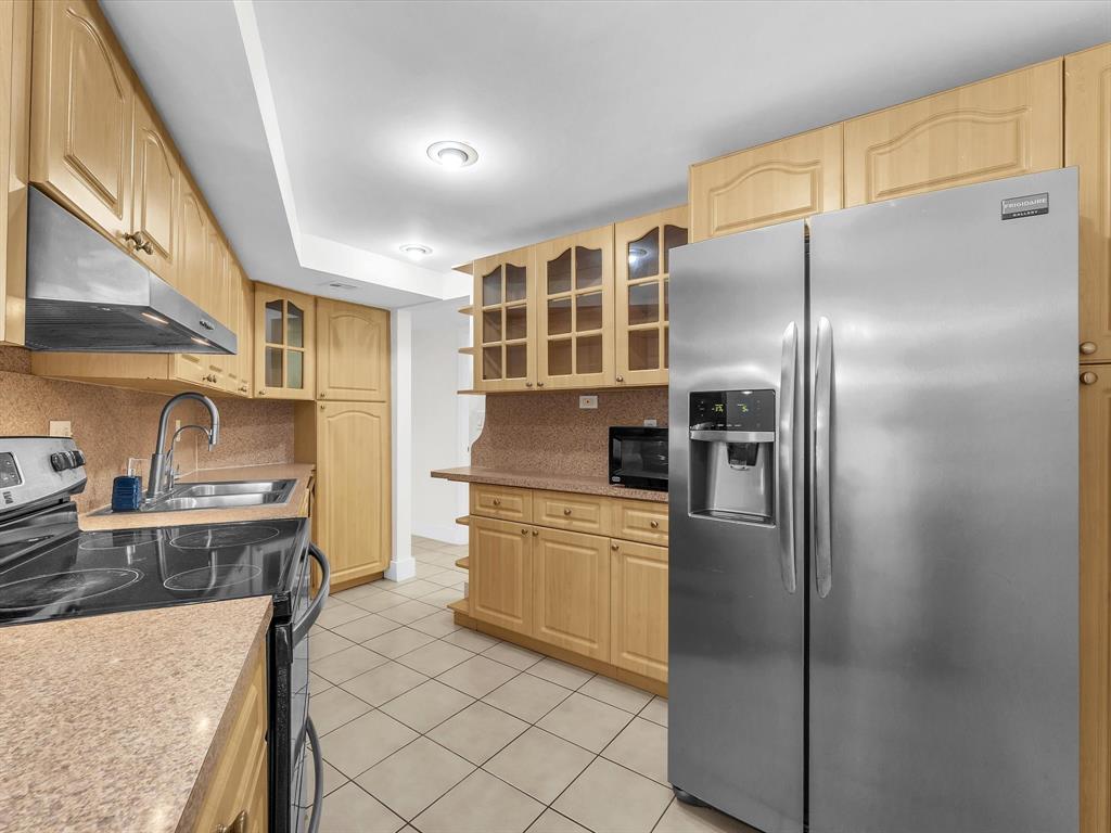 6901 Environ Boulevard, Unit 4D Lauderhill, FL 33319 - Photo 10 of 23 a kitchen with stainless steel appliances granite countertop a refrigerator a stove and a sink with wooden floor
