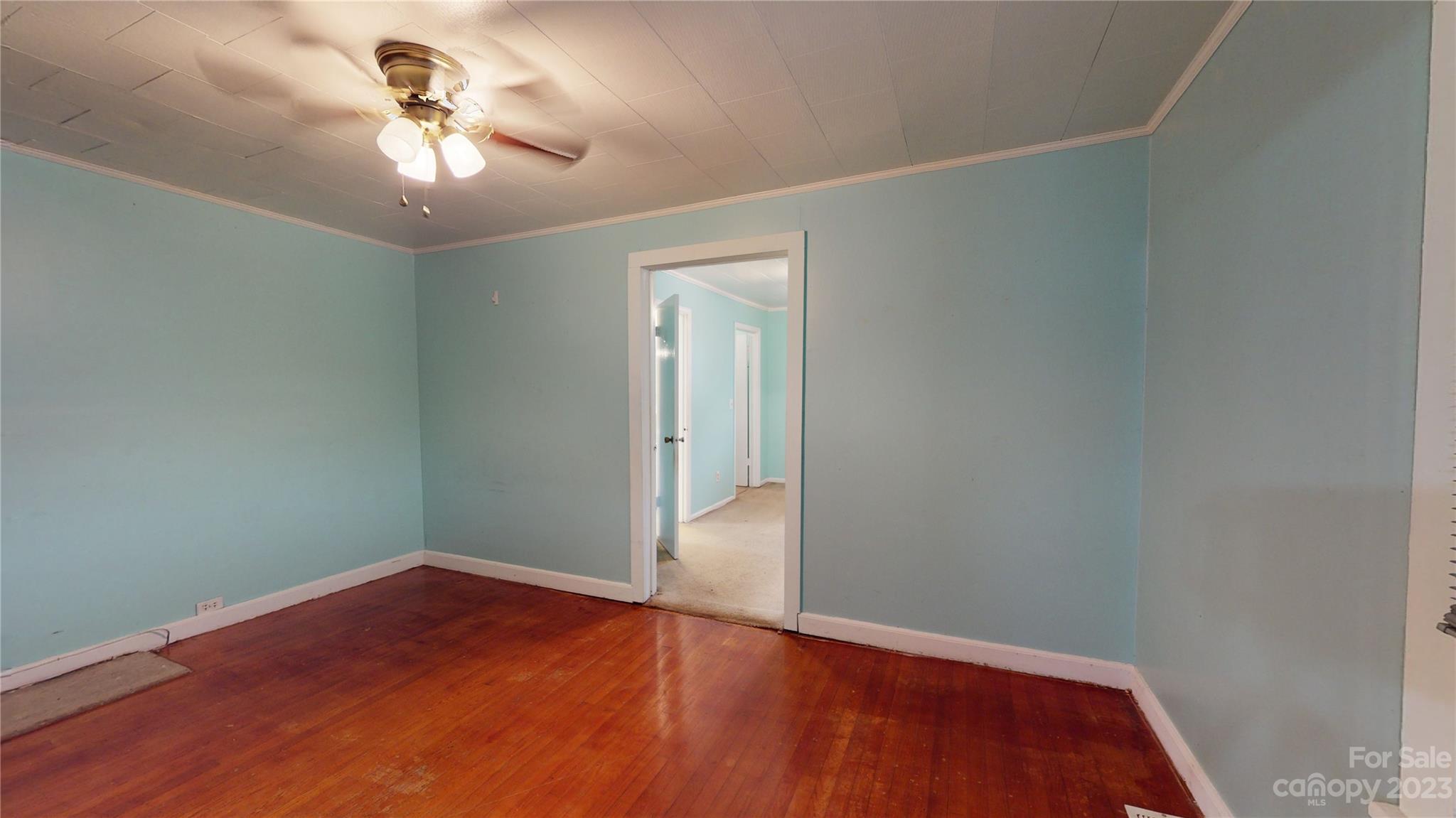 57 Lamar Street Marion, NC 28752 - Photo 18 of 48 an empty room with wooden floor and chandelier fan