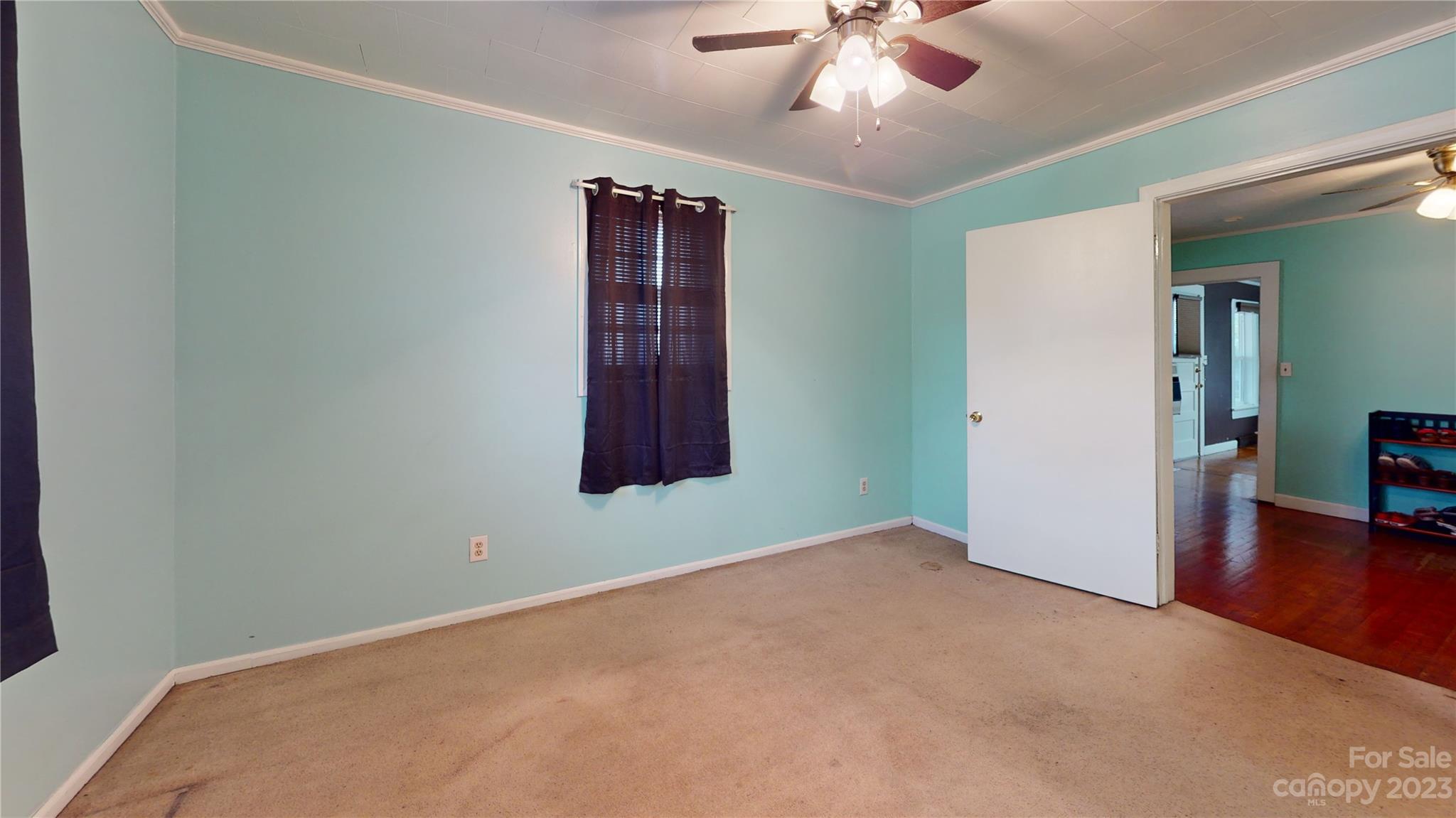 57 Lamar Street Marion, NC 28752 - Photo 29 of 48 an empty room with a chandelier fan and windows