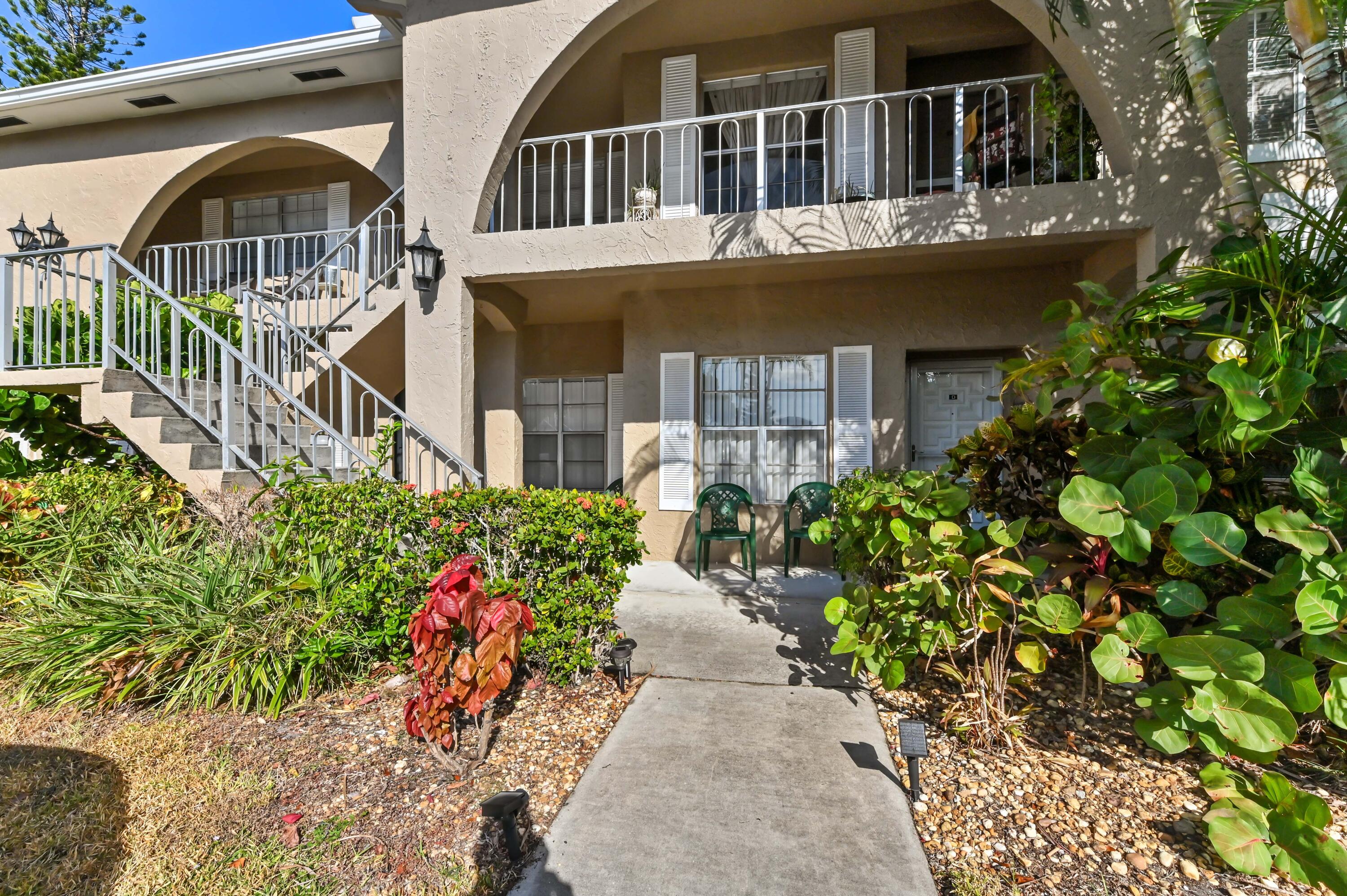 13960 Vía Flora, Unit H Delray Beach, FL 33484 - Photo 1 of 39 a front view of a house with a yard