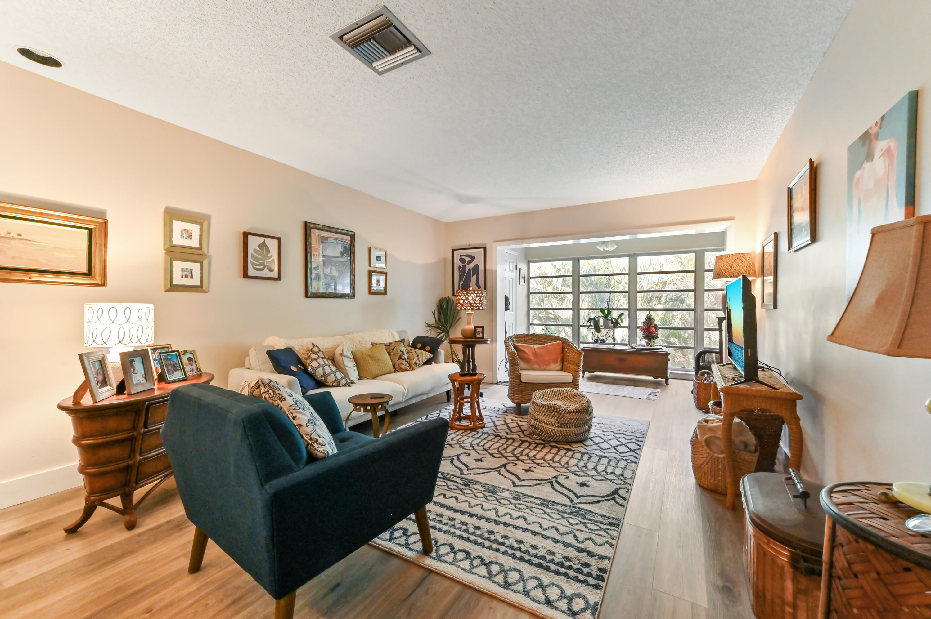 13960 Vía Flora, Unit H Delray Beach, FL 33484 - Photo 15 of 39 a living room with furniture large windows and wooden floor