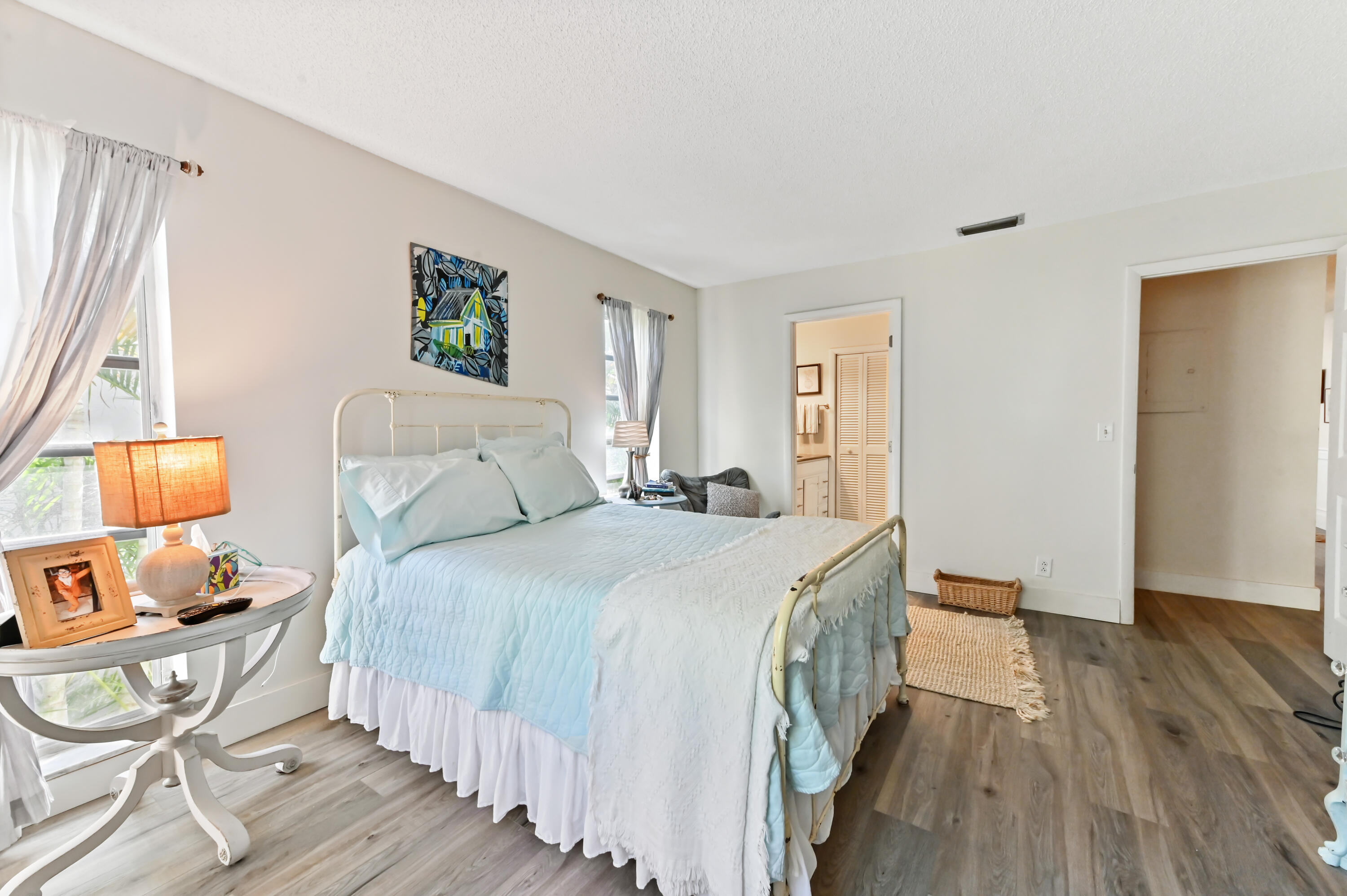 13960 Vía Flora, Unit H Delray Beach, FL 33484 - Photo 23 of 39 a bedroom with a bed and wooden floor