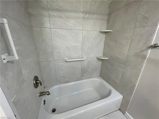 a bath tub sitting next to a shower