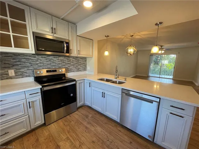 a kitchen with stainless steel appliances granite countertop wooden cabinets and a stove top oven
