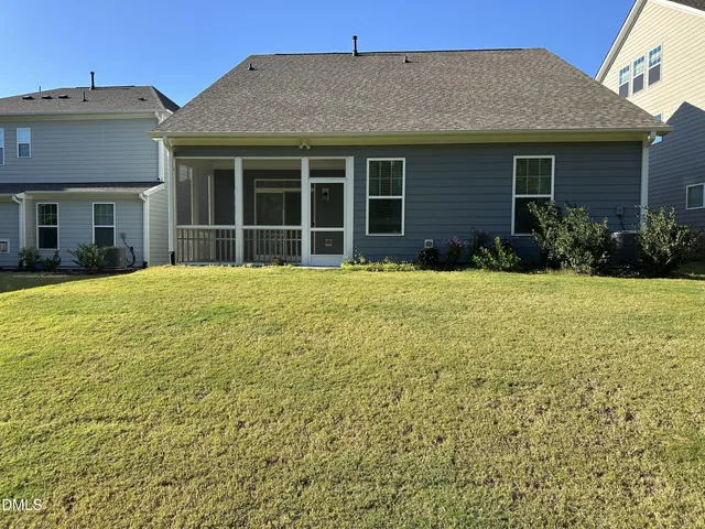 a view of a house with a yard and potted plants