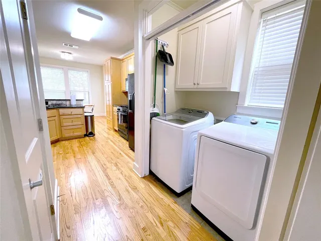a view of a kitchen with fridge and wooden floor
