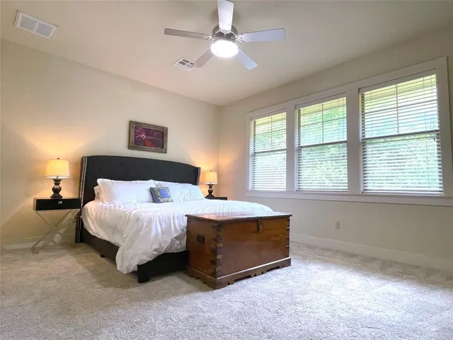 a spacious bedroom with a bed and a chandelier