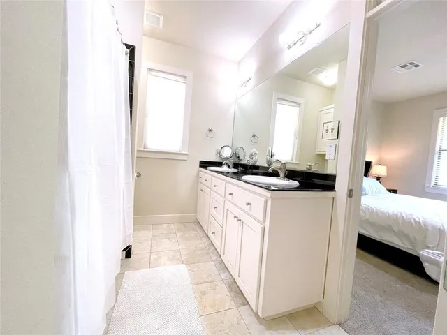 a bathroom with a double vanity sink a mirror and a bathtub