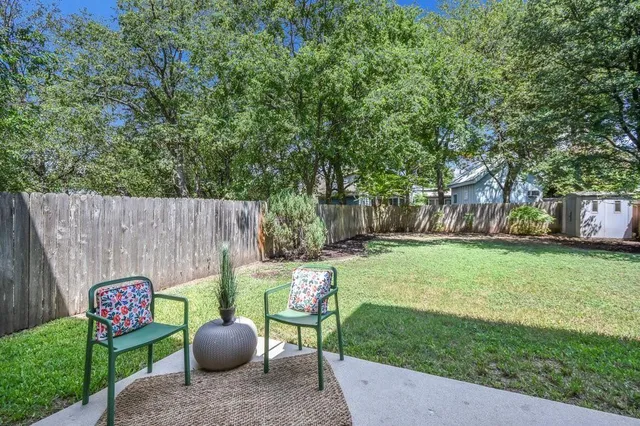 a view of a backyard with table and chairs and a large tree