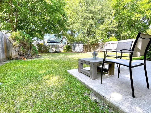 a view of a chairs and table in the back yard of the house