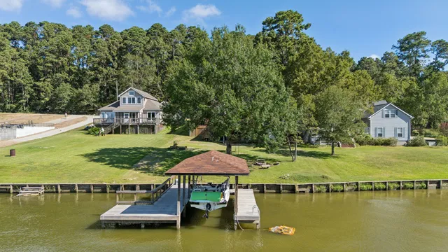 an aerial view of a house with pool lake view and boat