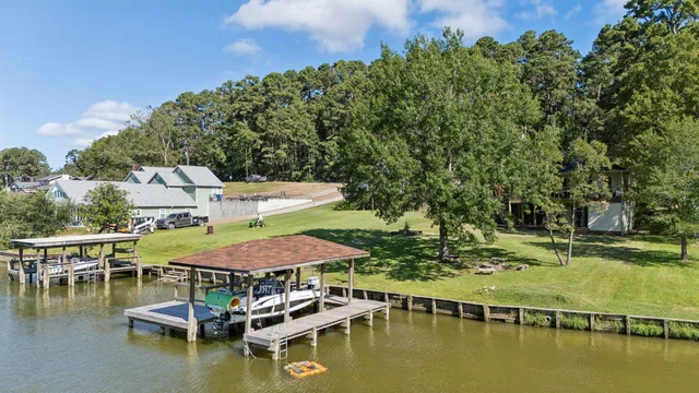 a view of a lake with lawn chairs under an umbrella