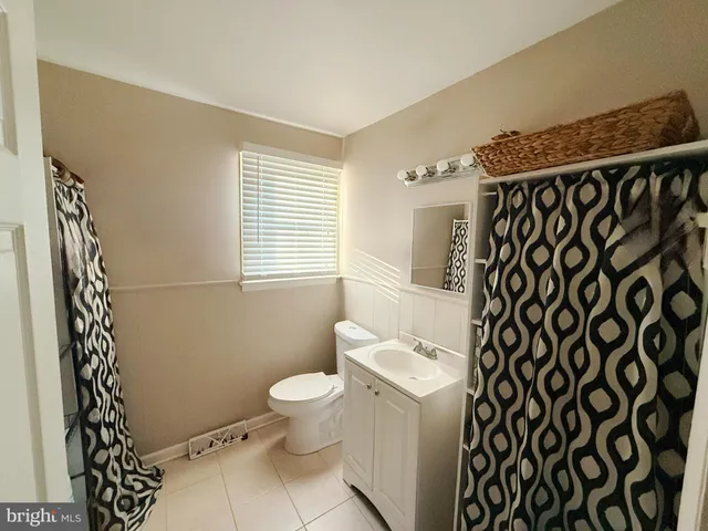 a bathroom with a toilet and a shower curtain
