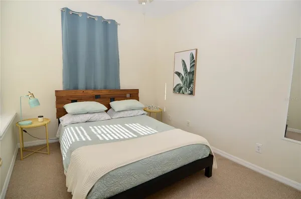 a bedroom with a bed and painting on the wall