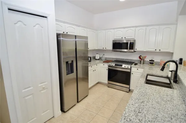 a kitchen with stainless steel appliances granite countertop a stove a sink and a refrigerator