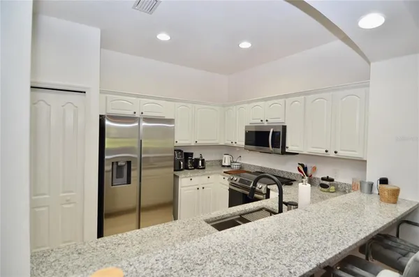 a kitchen with a refrigerator a stove a sink and a counter