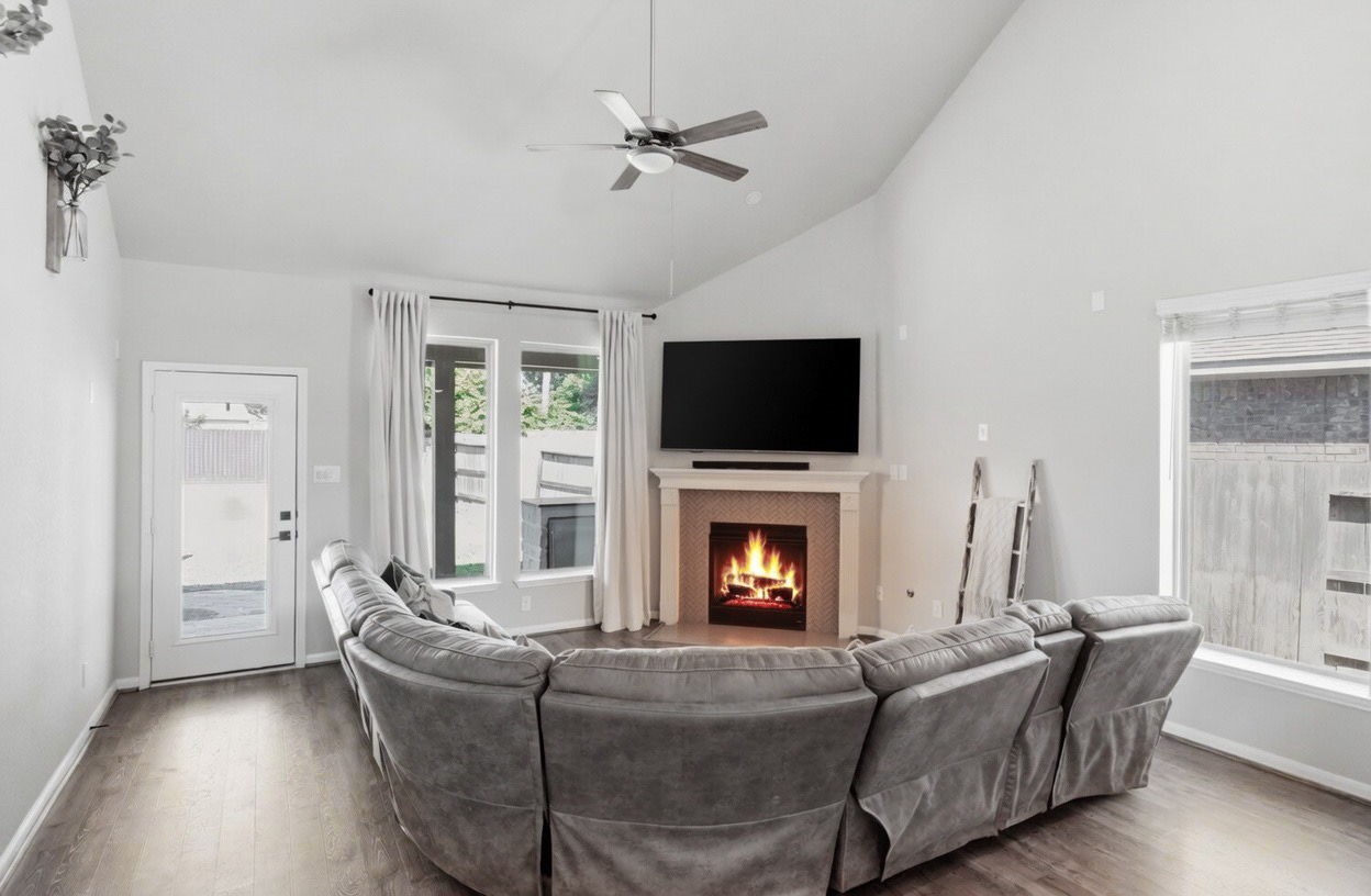 4334 Umber Shadow Drive Spring, TX 77386 - Photo 3 of 45 Family room features soaring ceilings, a cozy fireplace, expansive windows, and direct access to the covered patio.