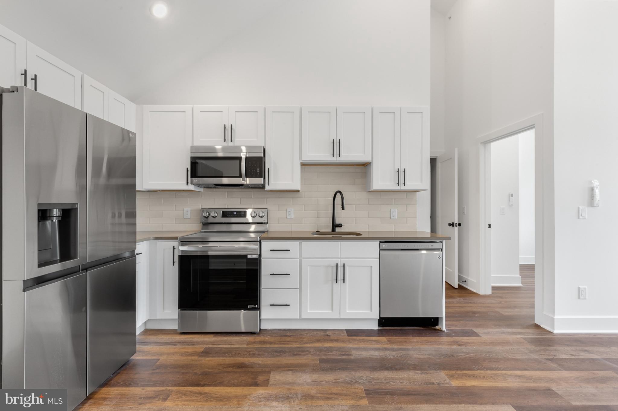 a kitchen with stainless steel appliances granite countertop a stove a refrigerator and a sink