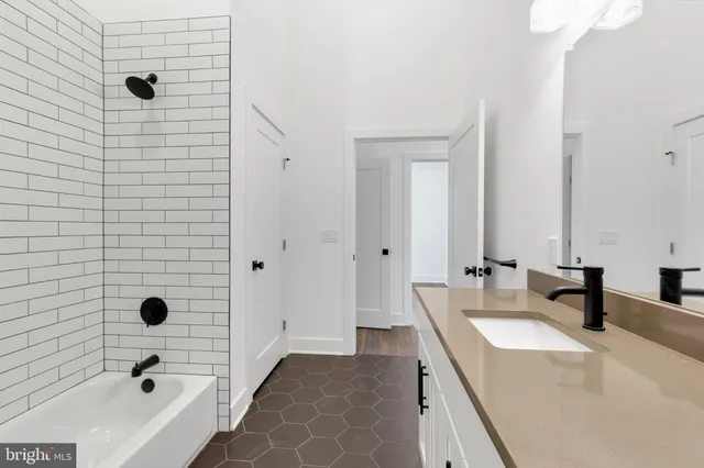 a bathroom with a tub sink and mirror