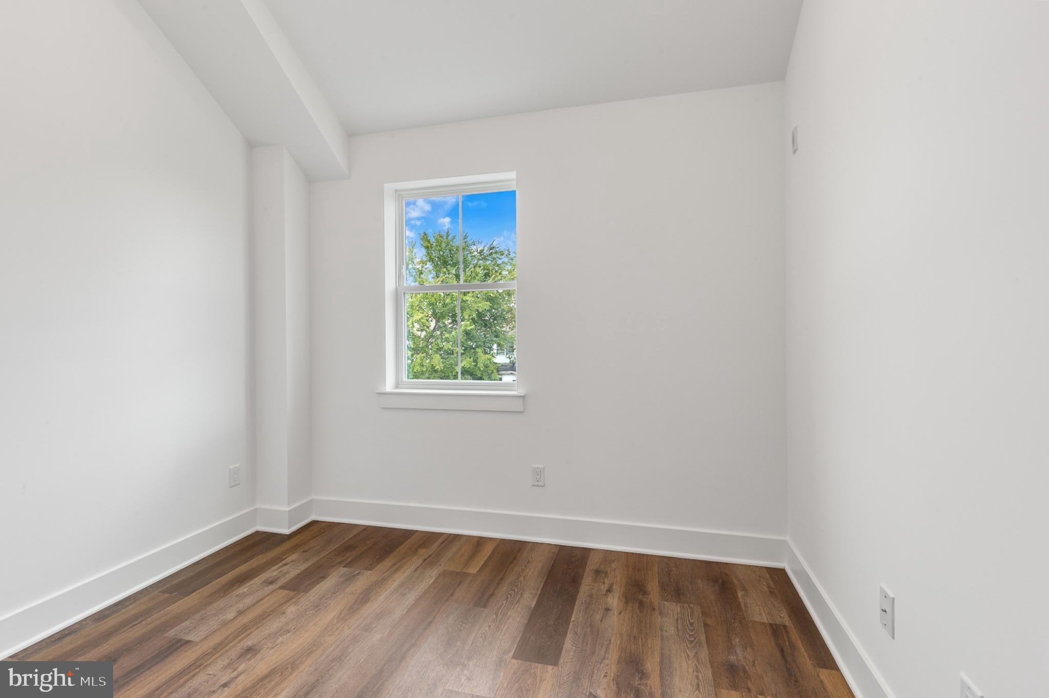 7037 Ridge Avenue, Unit 303 Philadelphia, PA 19128 - Photo 14 of 20 an empty room with wooden floor and windows