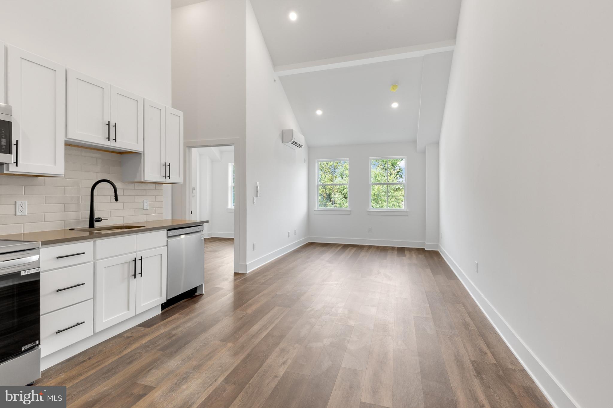 7037 Ridge Avenue, Unit 303 Philadelphia, PA 19128 - Photo 2 of 20 a large kitchen with granite countertop a large window a sink and stainless steel appliances