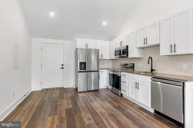 a kitchen with a refrigerator stove top oven and sink